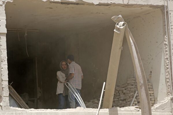 İsrail'in saldırıları sırasında İran'da bir apartmanın tamamen yıkılarak enkaza döndüğü ve bitişiğindeki bir binanın da dış cephesinin büyük ölçüde tahrip olduğu görüldü.  - Sputnik Türkiye