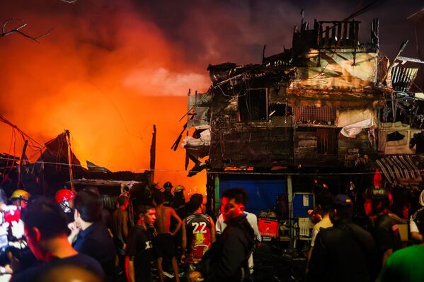 Ahşap ve kolay tutuşan malzemelerden yapılmış evlerde başlayan yangın kısa sürede büyüyerek mahalleyi sardı. - Sputnik Türkiye