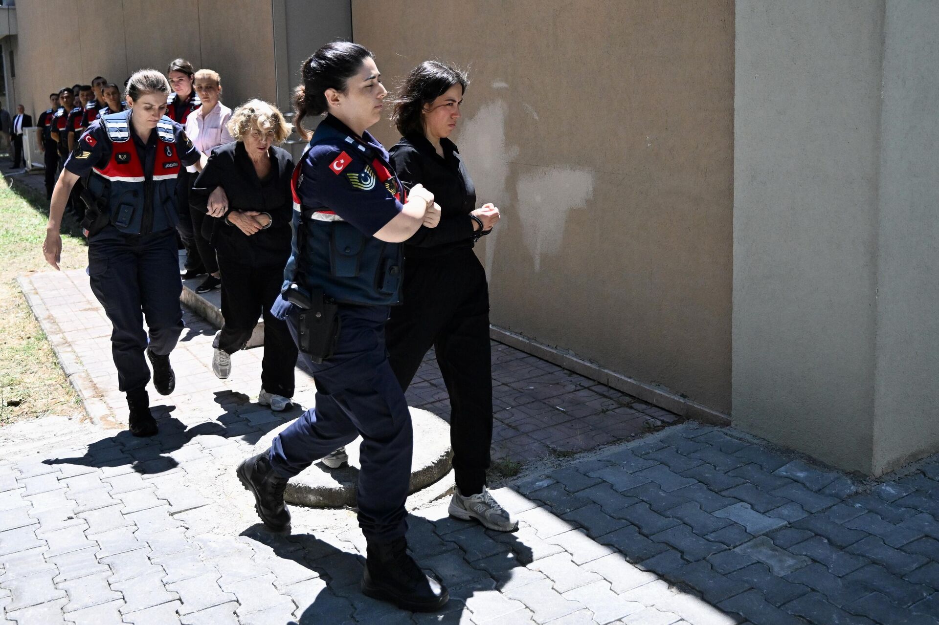 Bolu Kartalkaya Kayak Merkezi'nde 78 kişinin hayatını kaybettiği, 133 kişinin yaralandığı Grand Kartal Otel yangınına ilişkin davada tutuklu yargılanan otel sahibi Halit Ergül'ün kızı Ceyda Hacıbekiroğlu (önde sağda) ve eşi Emine Murtezaoğlu Ergül güvenlik güçleri tarafından geniş güvenlik önlemleri altında salona getirildi.  - Sputnik Türkiye, 1920, 08.07.2025