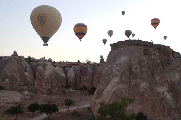 Kapadokya&#x27;daki doğal, kültürel ve tarihi zenginliklerle bezeli merkezleri ziyaret eden turistler, bölgenin simgelerinden olan sıcak hava balon turuna katılarak manzarayı gökyüzünden de izleme imkanı buldu. - Sputnik Türkiye
