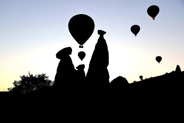 Yaz tatilinde kültür turizmini tercih eden yerli ve yabancı turistler, sıcak hava balon turuna katılarak Kapadokya bölgesini gökyüzünden keşfetti. - Sputnik Türkiye