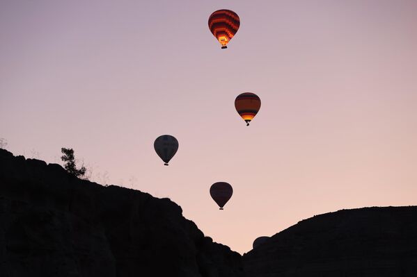 Göreme beldesi ile Çavuşin köyü çevresindeki alanlarda, henüz gün ağarmadan görevlilerce hazırlanan sıcak hava balonları, turistlerin sepetlere alınmasının ardından peş peşe bölge semalarına yükseldi. - Sputnik Türkiye