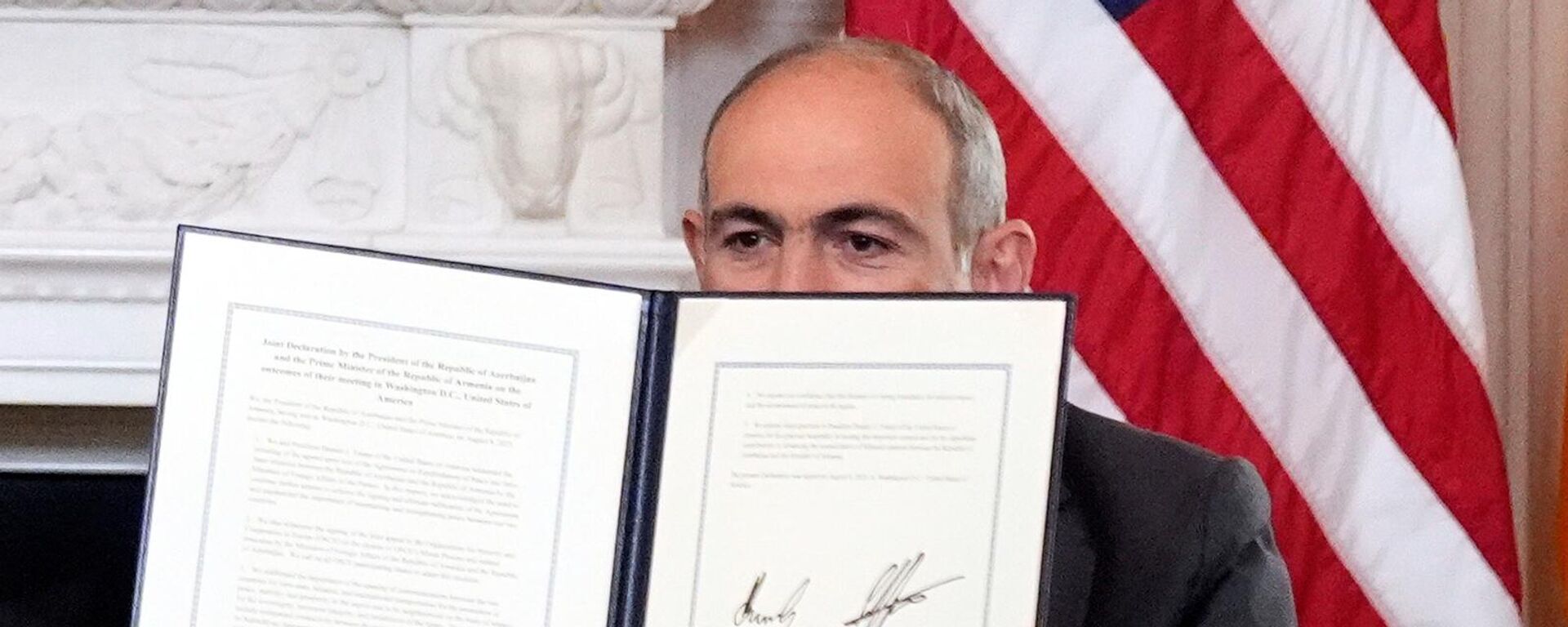 Премьер-министр Армении Никол Пашинян держит в руках подписанное трехстороннее соглашение во время церемонии с президентами США и Азербайджана в Белом доме (8 августа 2025). Вашингтон - Sputnik Türkiye, 1920, 09.08.2025
