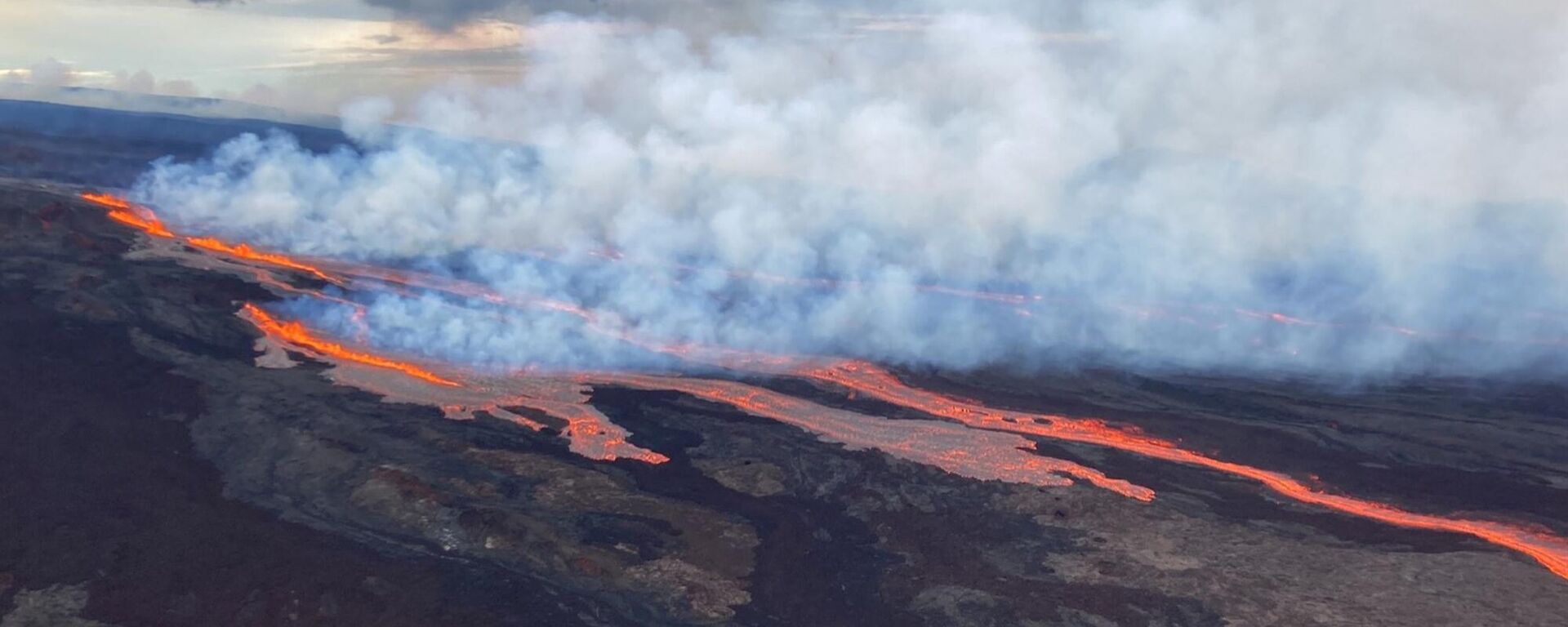 In this aerial photo released by the U.S. Geological Survey, the Mauna Loa volcano is seen erupting from vents on the Northeast Rift Zone on the Big Island of Hawaii, Monday, Nov. 28, 2022. Hawaii's Mauna Loa, the world's largest active volcano, began spewing ash and debris from its summit, prompting civil defense officials to warn residents on Monday to prepare in case the eruption causes lava to flow toward communities. - Sputnik Türkiye, 1920, 20.08.2025