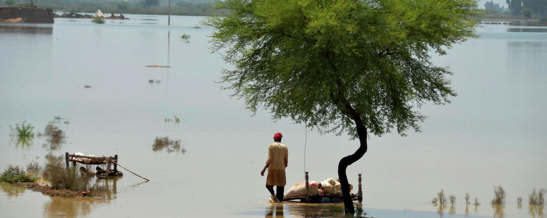 A villager uses cots to save usable items after salvaging from his flood-hit home, in Jaffarabad, a district of Pakistan's southwestern Baluchistan province, Saturday, Aug. 27, 2022. - Sputnik Türkiye, 1920, 28.08.2025