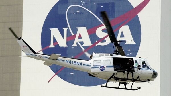  A NASA security helicopter flies by the NASA logo on the Vehicle Assembly Building - Sputnik Türkiye