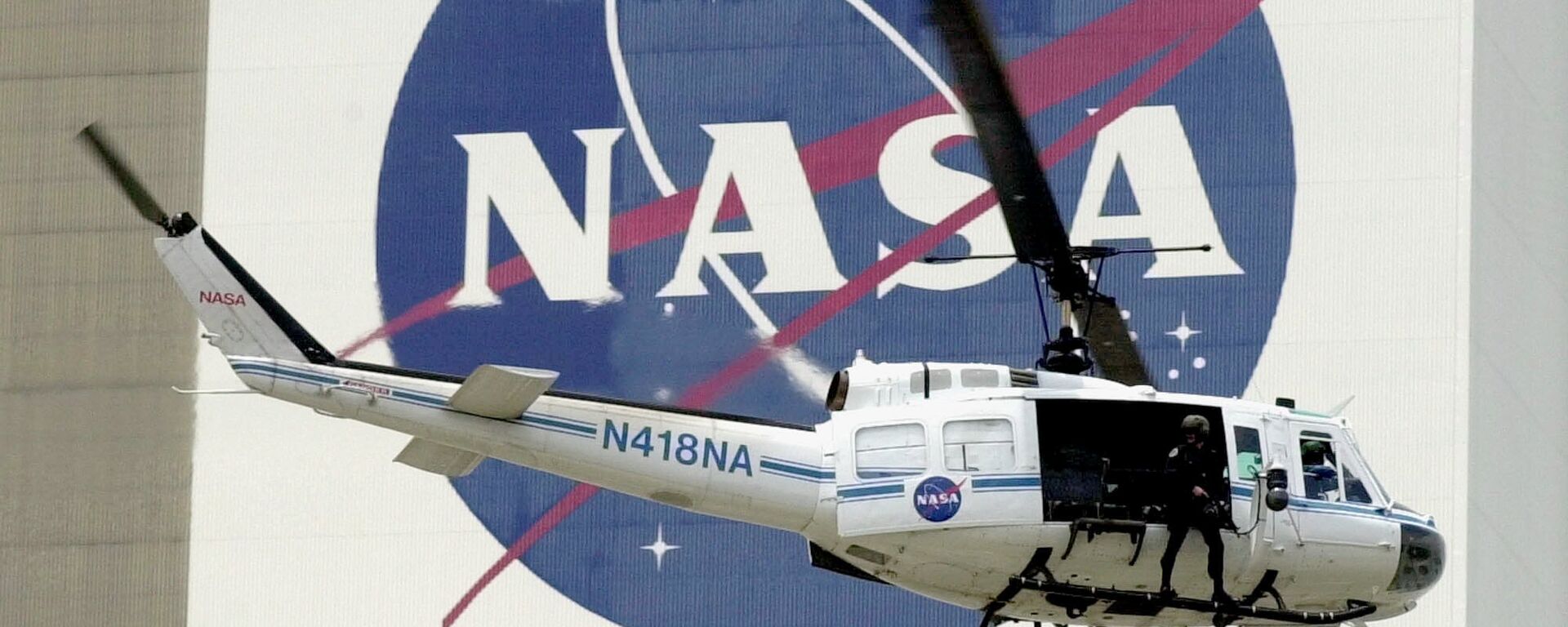  A NASA security helicopter flies by the NASA logo on the Vehicle Assembly Building - Sputnik Türkiye, 1920, 11.09.2025