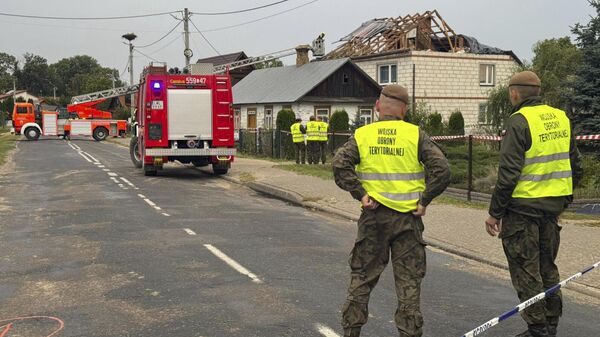 Firefighters and territorial defence officers stand close to the destroyed roof of a house after drones violated Polish airspace in Wyryki near Lublin, Poland, Thursday, Sept. 11, 2025.  - Sputnik Türkiye