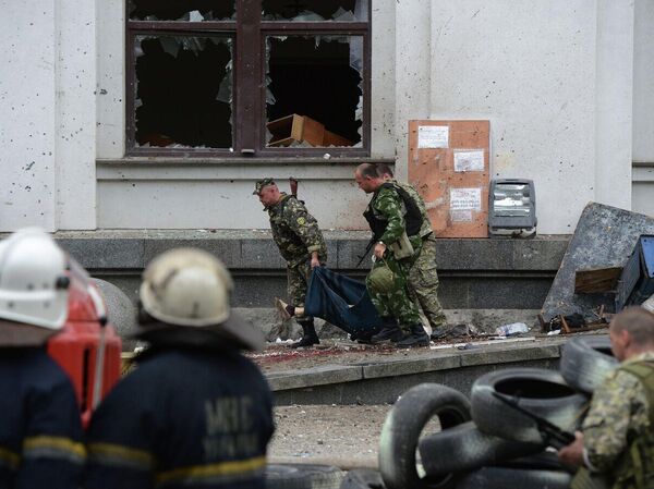 Halk milisleri, Ukrayna ordusunun Lugansk bölge idare binasına düzenlediği hava saldırısında yaralanan bir kişiyi taşıyor. - Sputnik Türkiye