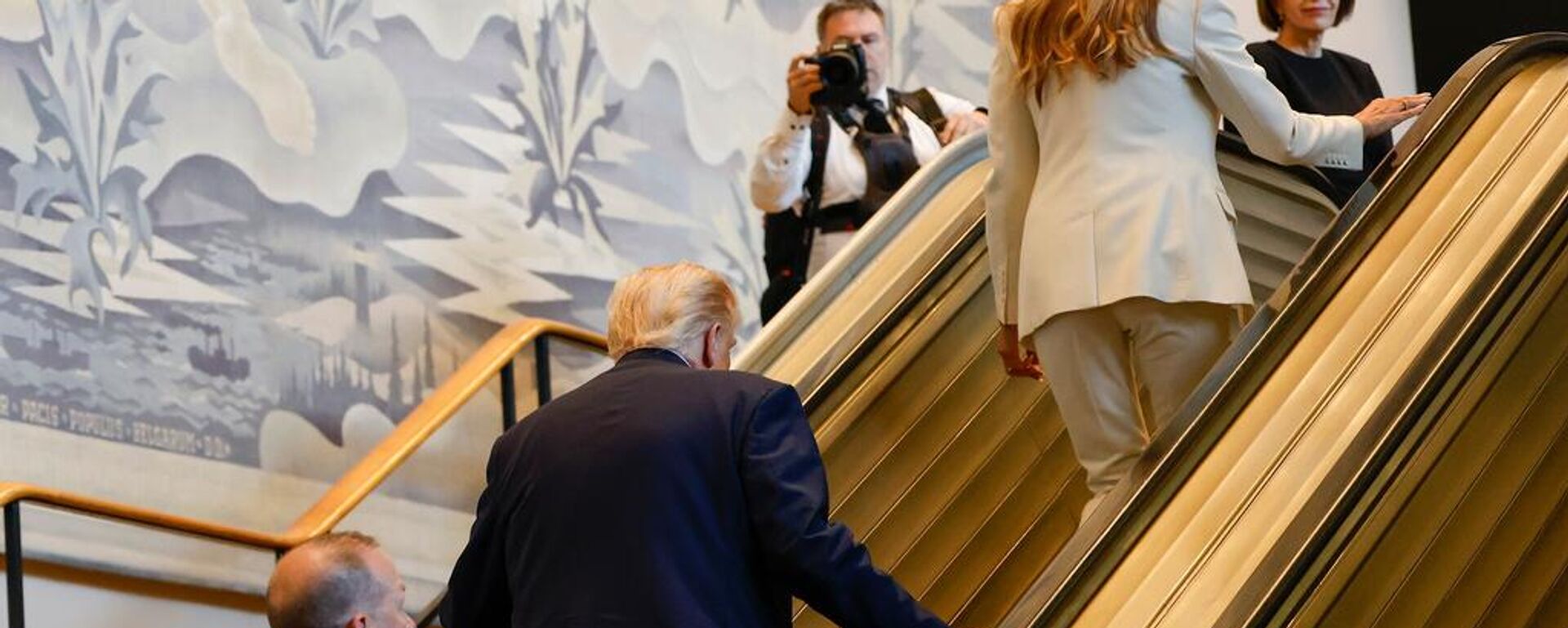 President Donald Trump, center, and First Lady Melania Trump, upper right, walk up the escalator after it stalled as he rode up to the General Assembly Hall, Tuesday, Sept. 23, 2025, at U.N. headquarters. - Sputnik Türkiye, 1920, 24.09.2025