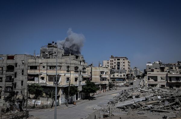 Saldırılar sonrasında mahalleden yoğun dumanlar yükseldi, bölgedeki yapıların ciddi hasar gördüğü bildirildi. - Sputnik Türkiye