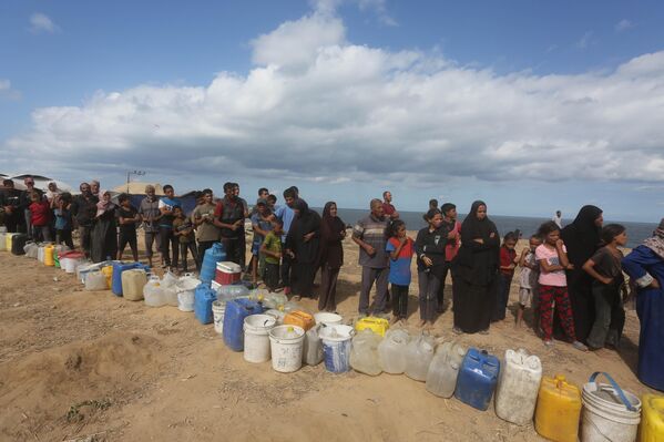 Gazze&#x27;nin orta kesiminde yer alan Nuseyrat Kampı&#x27;nda bir yardım kuruluşuna ait tankerlerden su alabilmek için kuyruğa girdi. - Sputnik Türkiye