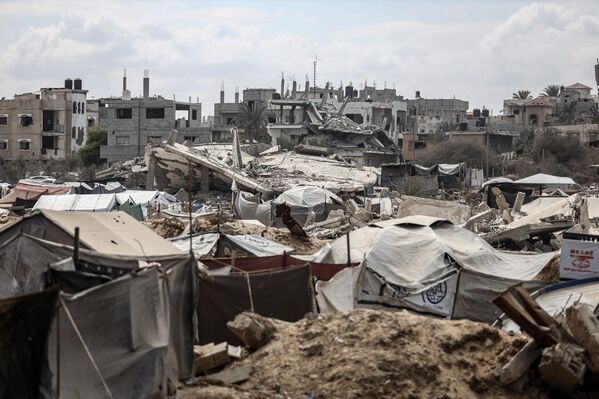 Gazze kentindeki yoğun saldırılar nedeniyle bölgeden zorunlu göçe tabi tutulan çok sayıda Filistinli, Nuseyrat Mülteci Kampı’nın batısındaki En-Nuvari Tepesi’nde, derme çatma çadırlarda zorlu koşullara rağmen hayatta kalma mücadelesi vermeye devam ediyor. - Sputnik Türkiye