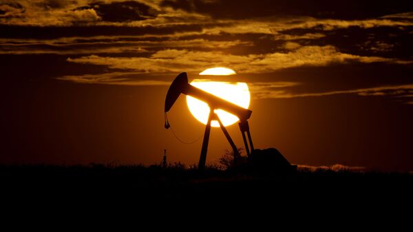 In this Wednesday, April 8, 2020, file photo, the sun sets behind an idle pump jack near Karnes City, Texas. Demand for oil continues to fall due to the new coronavirus outbreak. - Sputnik Türkiye