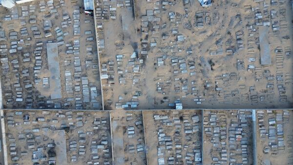 İsrail saldırılarında evleri yıkılan Filistinliler, Han Yunus'taki bir mezarlıkta kurdukları çadırda barınıyor - Sputnik Türkiye