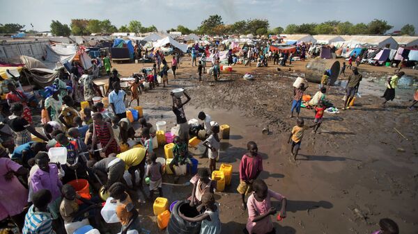 In this file photo of Sunday Dec. 29, 2013 file photo, displaced people gather around a water truck to fill containers at a United Nations compound which has become home to thousands of people displaced by the recent fighting, in the capital Juba, South Sudan - Sputnik Türkiye