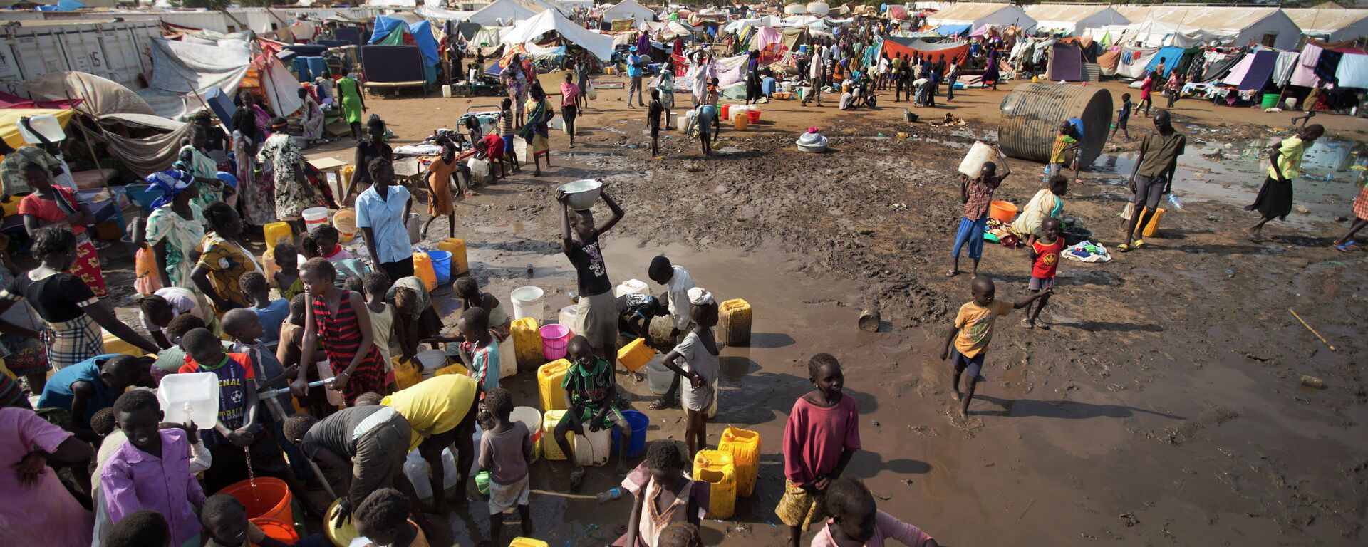 In this file photo of Sunday Dec. 29, 2013 file photo, displaced people gather around a water truck to fill containers at a United Nations compound which has become home to thousands of people displaced by the recent fighting, in the capital Juba, South Sudan - Sputnik Türkiye, 1920, 27.10.2025