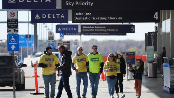Hava trafik kontrolörleri, 28 Ekim 2025 Salı günü, Michigan eyaletinin Romulus kentindeki Detroit Metropolitan Wayne County Havalimanı’nda, federal hükümetin kapanmasının hava yolculuğunu nasıl etkilediğini anlatan broşürler dağıttı. - Sputnik Türkiye