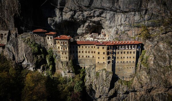 Sümela Manastırı, Trabzon&#x27;un Maçka ilçesinde, Altındere Vadisi&#x27;nin dik yamaçlarında 1200 metre yükseklikte yer alan tarihi bir Rum Ortodoks manastırı. Adı, Yunanca &#x27;Sou Mela&#x27;dan (Siyah Dağ) geliyor ve 1600 yıllık geçmişiyle Karadeniz&#x27;in en ikonik yapılarından biri. UNESCO Geçici Miras Listesi&#x27;ndedir ve hem Hristiyan hem de Müslüman hacılar için kutsal bir yerdir. - Sputnik Türkiye