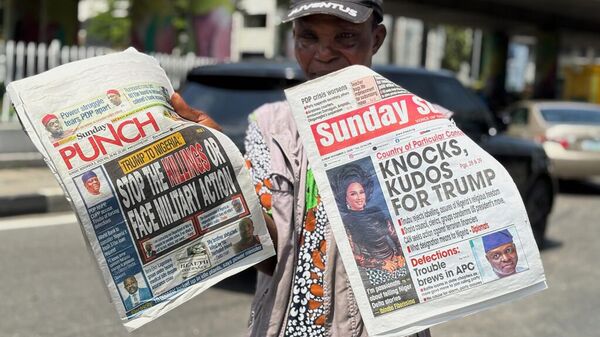 Nijerya'da Trump'ın açıklamalarının manşet olduğu gazeteleri gösteren bir gazete satıcısı. - Sputnik Türkiye