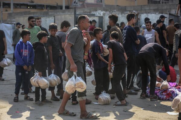 Gazze Şeridi’nin güneyindeki Han Yunus kentinin el-Mevasi bölgesinde bir hayır kurumu, İsrail saldırıları sonucu yerinden edilen Filistinlilere sıcak yemek dağıttı. - Sputnik Türkiye