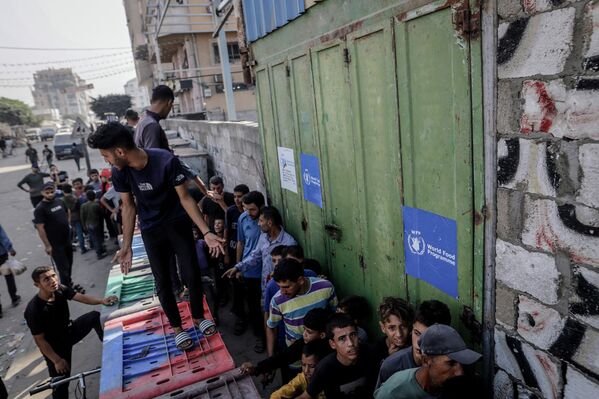 Dağıtım sırasında aralarında kadın ve çocukların da bulunduğu çok sayıda kişi uzun kuyruklar oluşturdu. Birçok aile, günler sonra ilk kez sıcak yemek yiyebildi. - Sputnik Türkiye