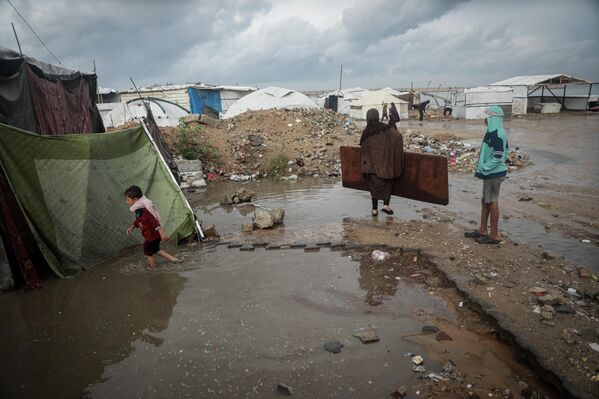 Saldırılar nedeniyle defalarca zorla yerinden edilen ve doğru düzgün eşyası kalmayan Filistinlilerin birkaç eşyası da ıslandı. - Sputnik Türkiye