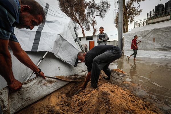 Yağmur nedeniyle bölgede su ve çamur birikintileri oluştu. Kamptaki Filistinliler, çadırlarına su girmemesi için önlem aldı. - Sputnik Türkiye