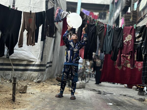 Güvenli bir alanın neredeyse kalmadığı kamplarda çocuklar, oyun oynayarak birkaç dakikalığına da olsa savaşın gölgesinden uzaklaşmaya çalışıyor. Ancak çoğu, barınma, beslenme ve hijyen gibi temel ihtiyaçlardan yoksun şekilde büyüyor. Çadırlarda geçirilen her gün, çocukların fiziksel ve duygusal yükünü daha da artırıyor. - Sputnik Türkiye