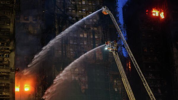 Hong Kong'un Tai Po bölgesinde dün 8 apartmanlı sitede çıkan yangını söndürme çalışmaları sürüyor - Sputnik Türkiye