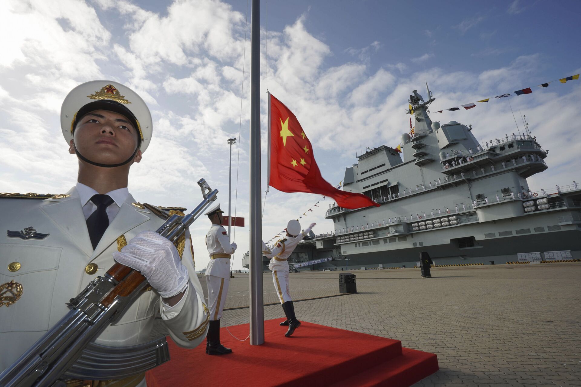 In this photo taken Dec. 17, 2019 and released Dec. 27, 2019 by Xinhua News Agency, Chinese honor guard raise the Chinese flag during the commissioning ceremony of China's Shandong aircraft carrier at a naval port in Sanya, south China's Hainan Province - Sputnik Türkiye, 1920, 15.12.2025