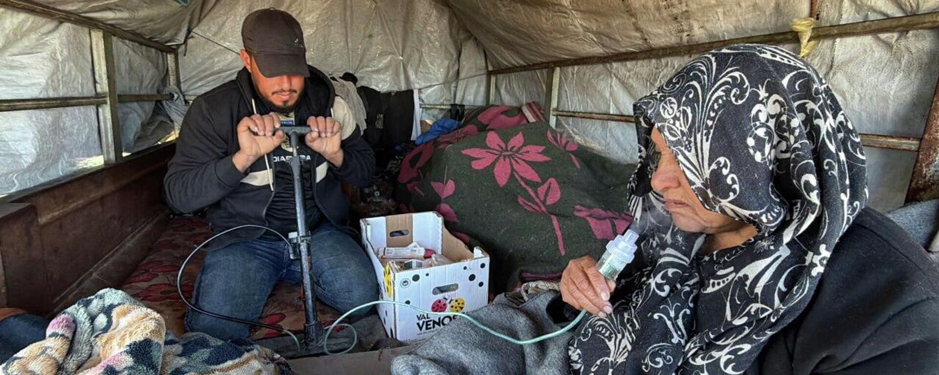 Gazze'de bir genç, hasta annesinin nefes almasını kolaylaştırmak için nebülizatör yerine bisiklet pompası kullanıyor - Sputnik Türkiye, 1920, 22.01.2026