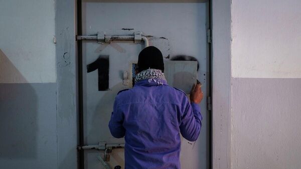 Suriye'de IŞİD'lilerin kaldığı hapishanede bir gardiyan pencereyi açarak mahkumla konuşuyor - Sputnik Türkiye