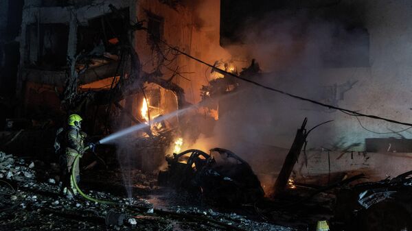 An Israeli firefighter works to put out a fire on a car, at the site of a projectile impact, after Iran launched missiles into Israel - Sputnik Türkiye