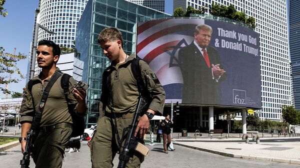 İsrail askerleri, Tel Aviv'de üzerinde 'Tanrı ve Donald Trump'a teşekkürler' yazılı bir billboard'un önünde yürüyor - Sputnik Türkiye