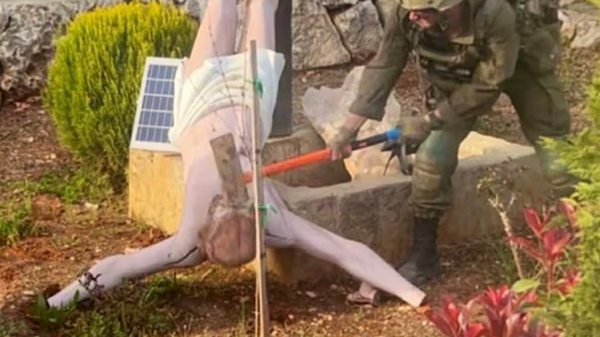 Görüntüde, İsrail Savunma Kuvvetleri (IDF) askerinin Lübnan'da İsa heykelini baltayla parçaladığı görülüyor./X - Sputnik Türkiye