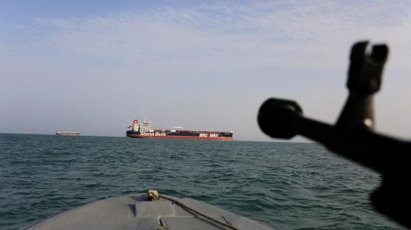 In this Sunday, July 21, 2019 photo, a speedboat of Iran's Revolutionary Guard trains a weapon toward the British-flagged oil tanker Stena Impero, which was seized in the Strait of Hormuz on Friday by the Guard, in the Iranian port of Bandar Abbas. Global stock markets were subdued Monday while the price of oil climbed as tensions in the Persian Gulf escalated after Iran's seizure of a British oil tanker on Friday.  - Sputnik Türkiye