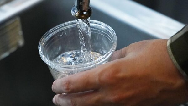 A cup of water is drawn from a faucet at Johnny T's Bistro and Blues, a midtown Jackson, Miss., restaurant and entertainment venue, Thursday, Sept. 1, 2022 - Sputnik Türkiye