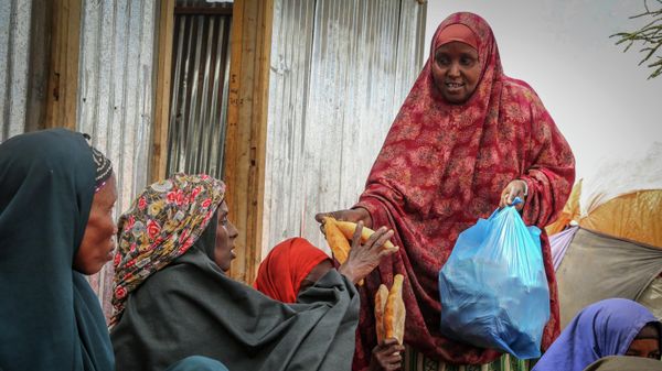 Somalis who fled drought-stricken areas receive charitable food donations from city residents after arriving at a makeshift camp for the displaced on the outskirts of Mogadishu, Somalia on June 30, 2022 - Sputnik Türkiye