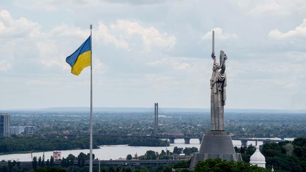Украинский национальный флаг развевается возле памятника Родине-Украине в Киеве - Sputnik Türkiye