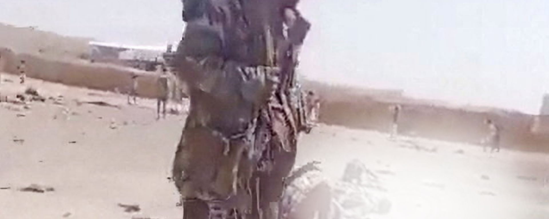 A screengrab from a video shows a person walking near bodies in the aftermath of a Houthi attack on Yemeni government military camp in Shabwa, Yemen, October 19, 2026. - Sputnik Türkiye, 1920, 19.10.2026