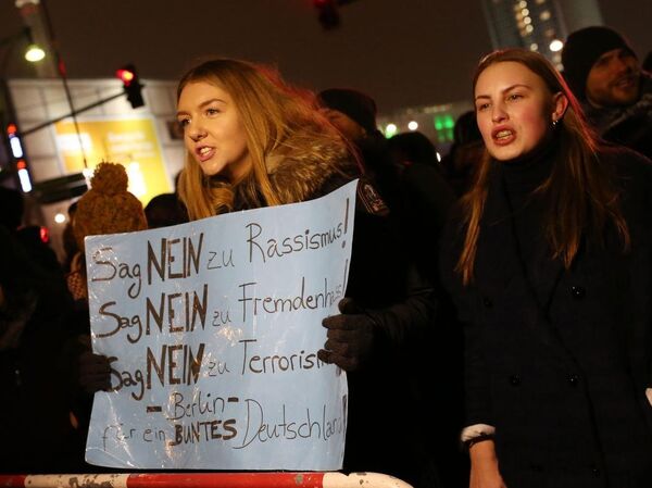 Alexanderplatz Meydanı’na yürüyen grup, Irkçılığa hayır, yabancı düşmanlığına hayır, teröre hayır dövizleri taşıdı. - Sputnik Türkiye