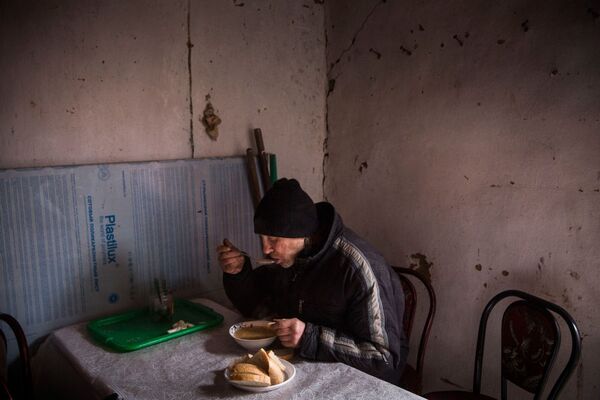 Ukrayna'nın Uglegorsk şehri sakini yardıma muhtaç olanlar için açılan lokantada çorba içiyor - Sputnik Türkiye