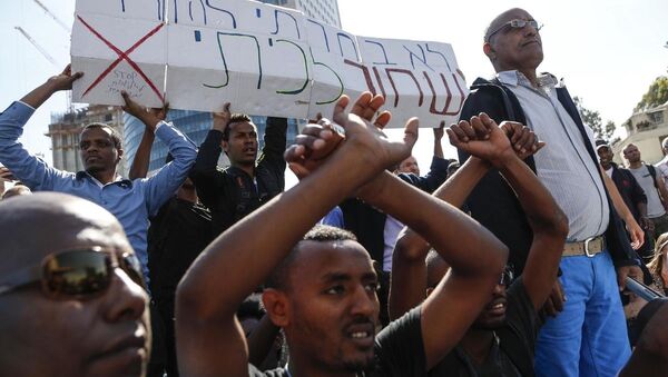 İsrail'deki Etiyopya asıllı Yahudiler, Tel Aviv’deki Azrieli Kulesi önündeki eylemlerinde 'Siyah değil, beyaz değil, hepimiz insanız' ve 'Irkçılığa ve ayrımcılığa hayır' ve 'Artık söz değil eylem istiyoruz' sloganları attı. - Sputnik Türkiye