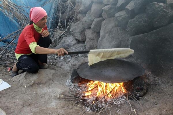 Gıda sıkıntısı çeken Suriyeliler, kendi ekmeklerini pişiriyorlar. - Sputnik Türkiye