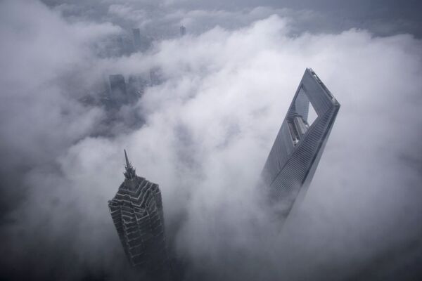 Şanghay’da bankaların yoğunlaştığı Pudong semtindeki Jin Mao Kulesi ve  Şanghay Dünya Finans Merkezi sis içinde. - Sputnik Türkiye