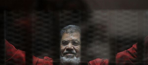 Mursi, 'Katar adına casusluk' yaptığı gerekçesiyle yargılandığı davanın duruşmasına ilk kez 'kırmızı idam mahkumu kıyafetiyle' getirildi. - Sputnik Türkiye