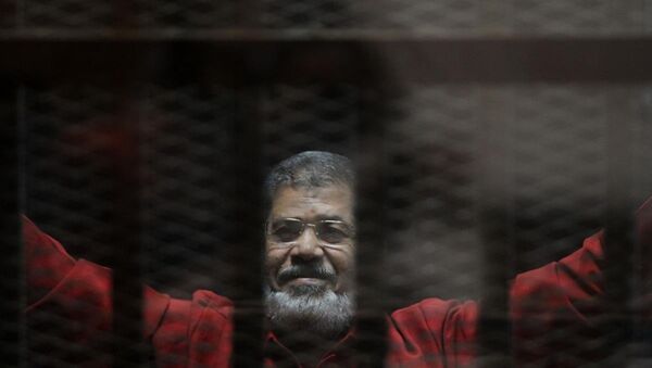 Mursi, 'Katar adına casusluk' yaptığı gerekçesiyle yargılandığı davanın duruşmasına ilk kez 'kırmızı idam mahkumu kıyafetiyle' getirildi. - Sputnik Türkiye