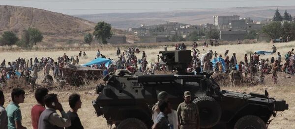 Halep'e bağlı Kobani kentinde (Ayn el Arap), DAEŞ ile bazı Kürt gruplar arasındaki çatışmalardan kaçan bir grup Suriyeli sınırda bekliyor. - Sputnik Türkiye
