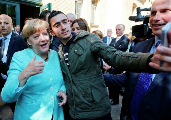 Yurttaki göçmenler, kendilerini ziyarete gelen Almanya Başbakanı Merkel'i selfie çekmeden bırakmadı.  - Sputnik Türkiye